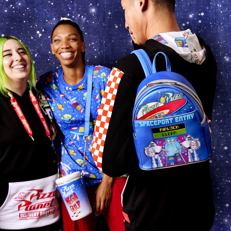 Three people hanging out and smiling while wearing the Toy Story Pizza Planet Collection with the Space Entry Mini Backpack in the foreground